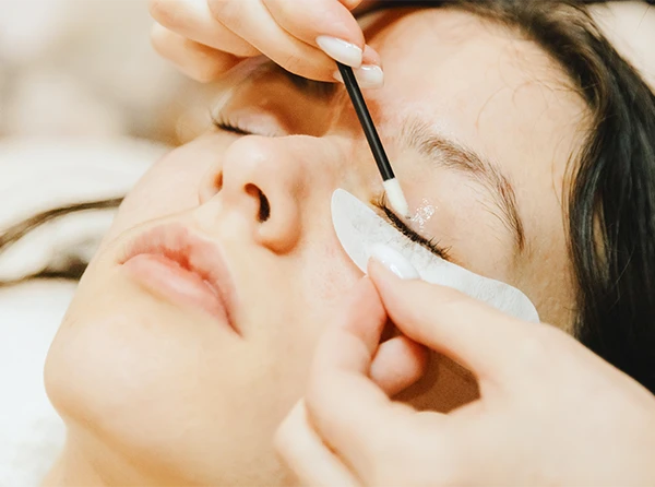 Woman receiving eyelash lift service.